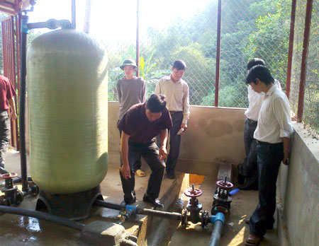 Cán bộ Trung tâm nước sạch và VSMT tỉnh Yên Bái kiểm tra bể lọc nước sạch tại xã Gia Hội, huyện Văn Chấn trước khi đem vào sử dụng.