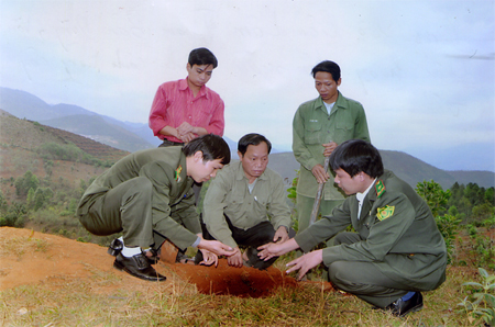 Cán bộ kiểm lâm Trạm Bản Dõng, Văn Chấn hướng dẫn người dân cách đào hố trồng cây trẩu.
