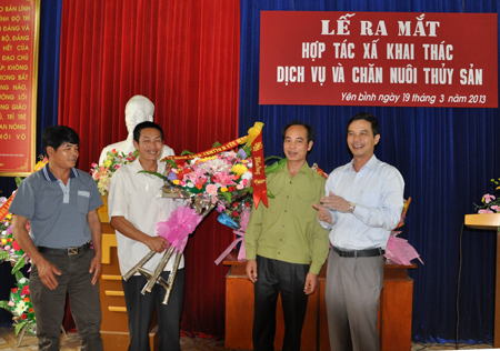 Lãnh đạo Huyện ủy Yên Bình tặng hoa cho Ban chủ nhiệm HTX trong lễ ra mắt.
