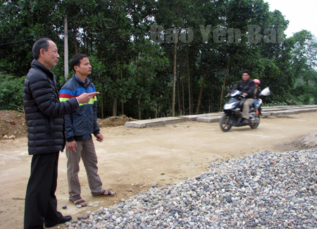 Ông Nguyễn Hồng Nghi (bên trái) kiểm tra chất lượng thi công các tuyến đường giao thông nông thôn.