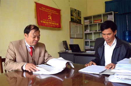 Đồng chí Trần Ngọc Liêm (bên trái) - Bí thư Đảng ủy thị trấn Mậu A kiểm tra bản viết thu hoạch sau học tập Nghị quyết Trung ương 4 (khóa XII) của các đảng viên.