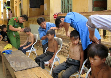 Đoàn viên thanh niên cắt tóc cho học sinh Trường Phổ thông DTBT TH&THCS Khao Mang.
