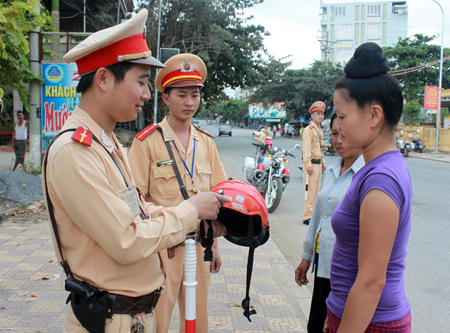 Cảnh sát giao thông Công an thị xã Nghĩa Lộ nhắc nhở nhân dân sử dụng mũ bảo hiểm đúng tiêu chuẩn.