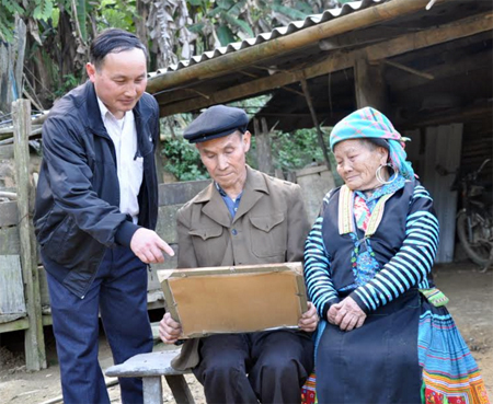 Già làng Tráng Nủ Cao (giữa) nâng niu tấm bằng khen được UBND huyện Trạm Tấu trao tặng vì đã có thành tích xuất sắc trong thực hiện Chỉ thị 03 của Bộ Chính trị năm 2016.