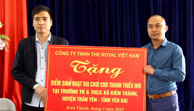 Đại diện Công ty TNHH The Royal Việt Nam trao tặng điểm vui chơi cho học sinh Trường Tiểu học và THCS Kiên Thành, huyện Trấn Yên.