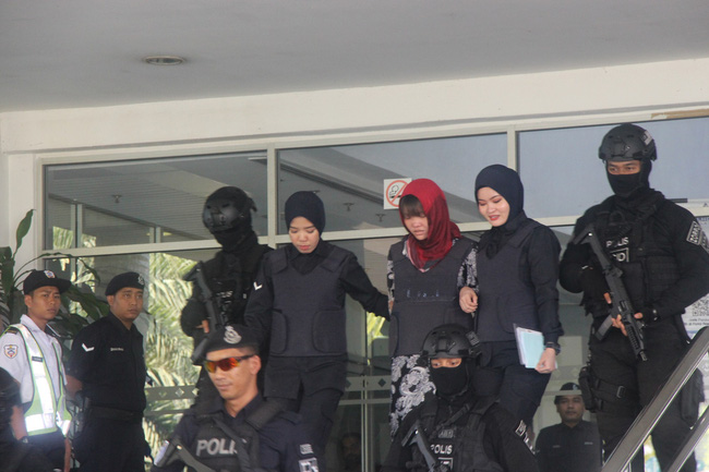 Cảnh sát dẫn giải Đoàn Thị Hương ra xe sau khi kết thúc phiên xét xử ngày 14/3.