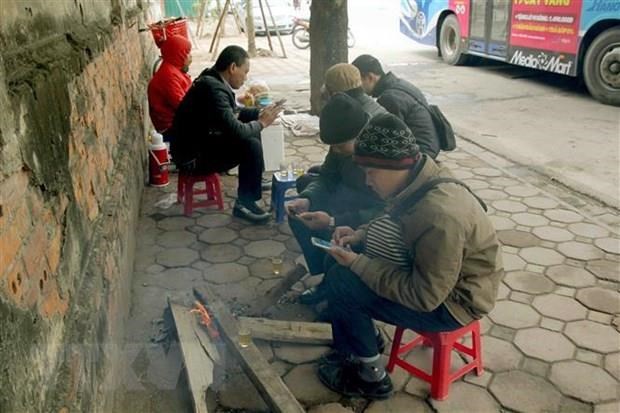 Người dân trên phố Trần Khánh Dư đốt củi để sưởi ấm.
