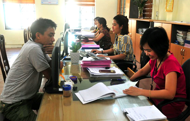 Hỗ trợ người nộp thuế tại bộ phận “một cửa” Chi cục Thuế huyện Trấn Yên.