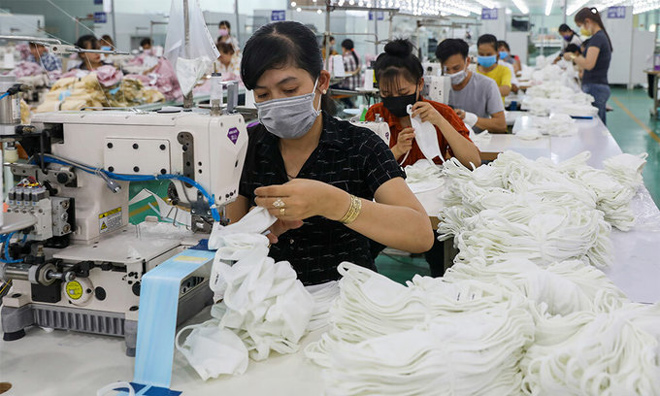 Workers manufacture masks in a factory in southern Long An Province on February 29, 2020.