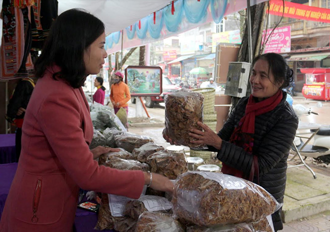 Chị Vũ Thị Hồng Duyên (bên trái) giới thiệu sản phẩm măng khô cho khách hàng.