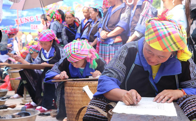 Phụ nữ Mông Mù Cang Chải thi vẽ hoa văn bằng sáp ong trên vải.