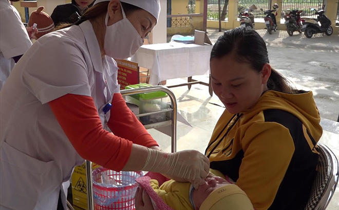 Cán bộ Trạm Y tế xã Sơn Lương cho trẻ em uống vitamin.