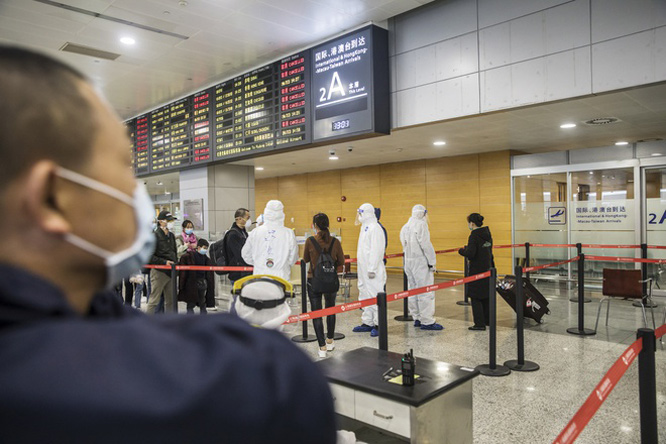 Nhân viên an ninh mặc bộ đồ bảo hộ tại sân bay quốc tế Thượng Hải ngày 10-3.