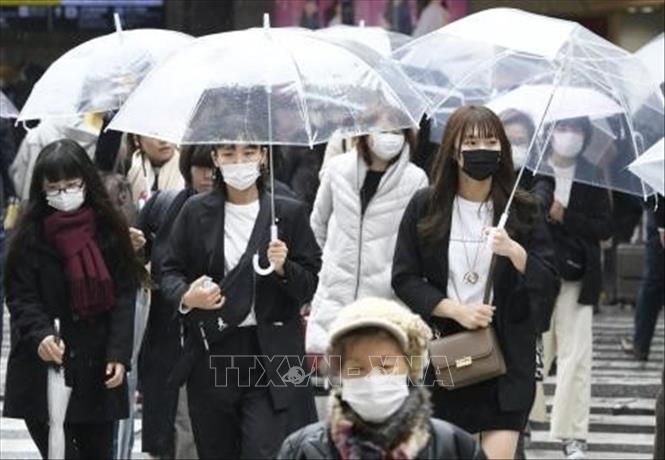 Người dân đeo khẩu trang phòng tránh COVID-19 tại Osaka, Nhật Bản.