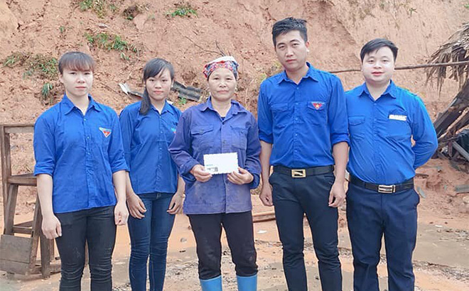 Anh Hà Đình Thao - Bí thư Đoàn xã Hưng Khánh (thứ 2, phải sang) trao tiền hỗ trợ cho hộ dân trên địa bàn bị thiệt hại do mưa bão.