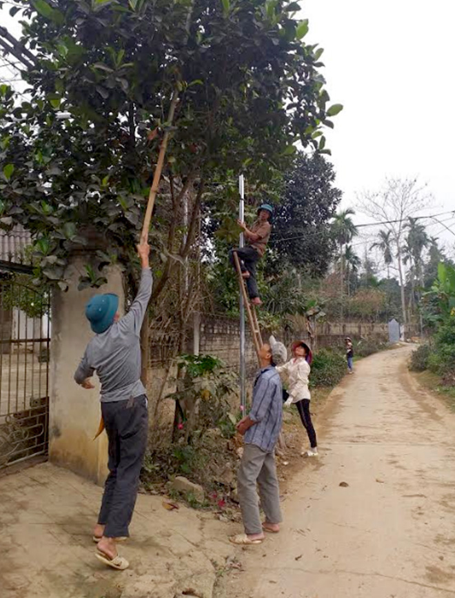 Hội viên nông dân thị trấn Cổ Phúc, huyện Trấn Yên lắp đặt hệ thống đèn chiếu sáng đoạn đường dẫn cầu Cổ Phúc đến giáp xã Việt Thành.