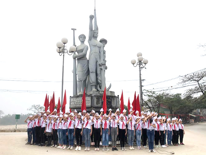 Các em học sinh lớp 5C, Trường Tiểu học Nguyễn Trãi thực hiện nghi thức chào cờ tại buổi tham quan thực tế Di tích lịch sử cấp quốc gia Bến Âu Lâu.