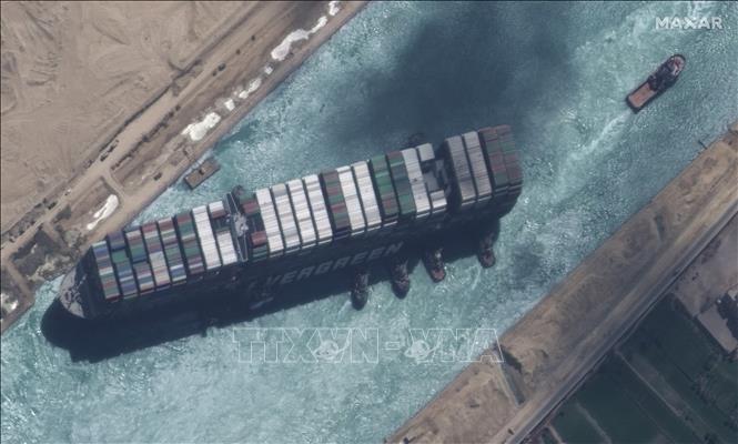 Toàn cảnh siêu tàu container Ever Given (trái) bắt đầu nổi lên và được tàu kéo lai dắt sau một tuần mắc kẹt trên kênh đào Suez ở Ai Cập, ngày 29/3/2021. Ảnh chụp từ vệ tinh