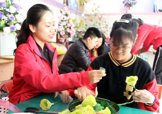 Giáo viên dạy nghề Trung tâm Trợ giúp và Can thiệp sớm trẻ khuyết tật Hương Giang, thành phố Yên Bái dạy nghề làm hoa, tạo việc làm cho tre khuyết tật.