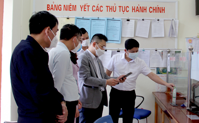 Các đại biểu tham quan, trải nghiệm dịch vụ thu quỹ đóng góp của nhân dân bằng hình thức quét mã QR.