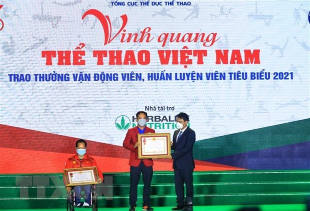 Thứ trưởng Bộ VH, TT và DL Hoàng Đạo Cương trao Huân chương Lao động hạng Nhì, Ba cho vận động viên Lê Văn Công và huấn luyện viên Lê Quang Thái. (Ảnh: TTXVN)