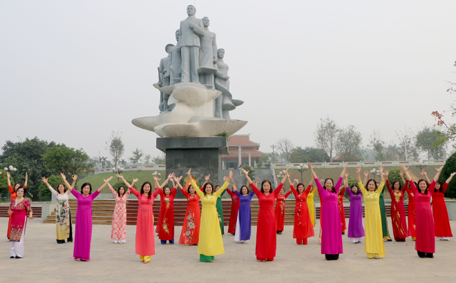 Các bà, các chị nhảy dân vũ trong trang phục áo dài tại Di tích lịch sử Nguyễn Thái Học, thành phố Yên Bái.