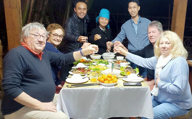 Foreign tourists enjoy dishes imbued with national identity at Homestay Loan Khang in Sa Ren village, Nghia Loi commune, Nghia Lo town.