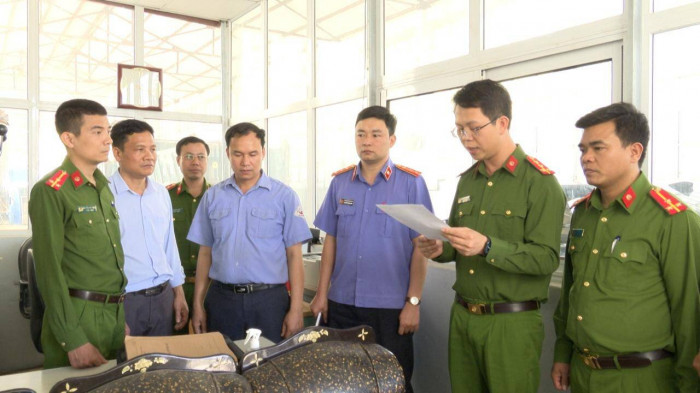 Cơ quan điều tra đọc Quyết định tạm giữ hình sự đối với Nguyễn Văn Chiến - đăng kiểm viên tại Trung tâm Đăng kiểm xe cơ giới tỉnh Lai Châu. Ảnh: Công an Lai Châu