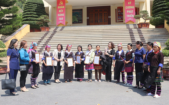 Cán bộ Hội Liên hiệp Phụ nữ tỉnh và huyện Mù Cang Chải động viên chị em học viên tích cực thực hành tiếng Việt sau khi tốt nghiệp lớp xóa mù chữ.