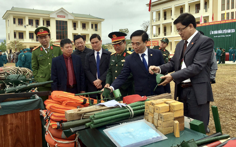 Đồng chí Đỗ Việt Bách - Bí thư Thị ủy, Bí thư Đảng ủy quân sự thị xã (thứ 2, phải sang) tham quan hệ thống cơ sở vật chất, mô hình đạo cụ phục vụ huấn luyện.