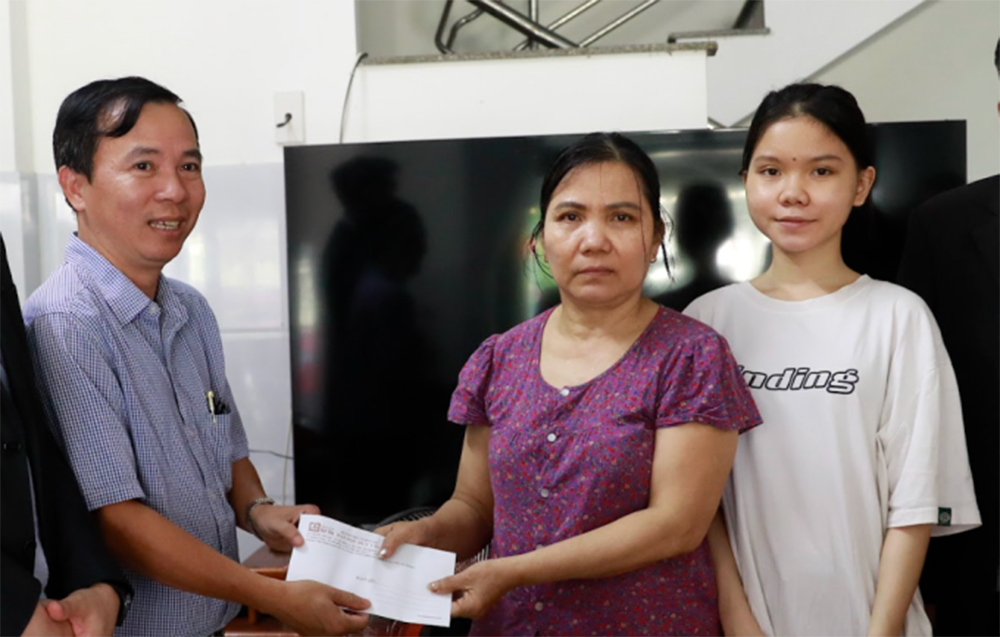 Lãnh đạo Trường ĐH Duy Tân trao học bổng cho em Dương Thị Mỹ Linh.