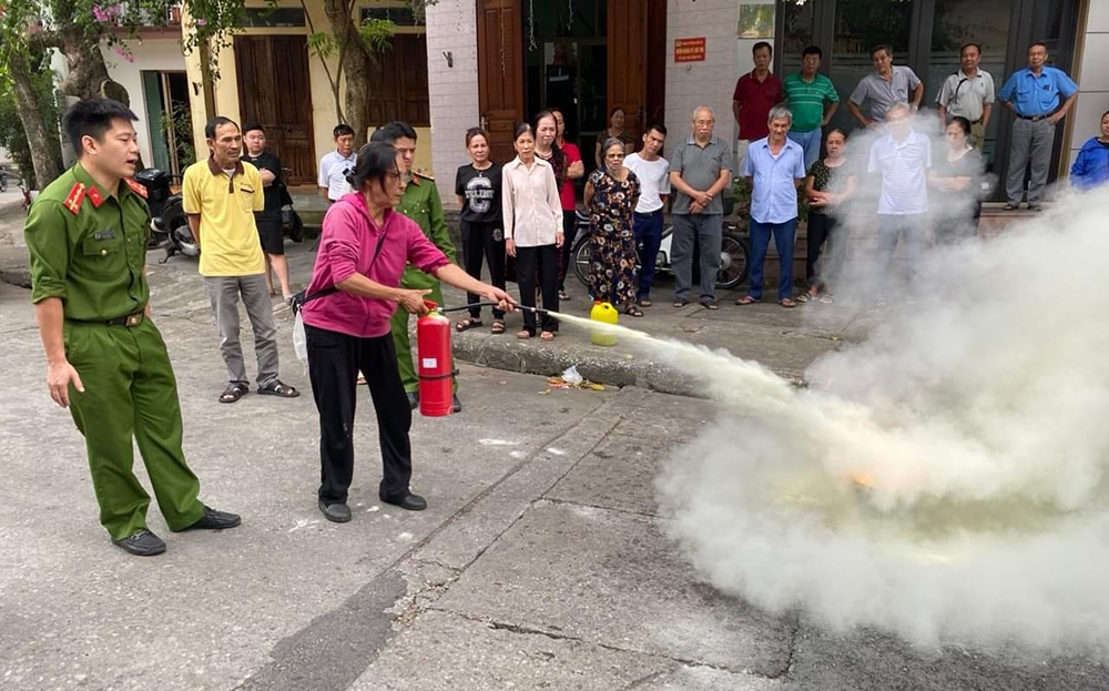 Cán bộ Công an thành phố Yên Bái tập huấn cho người dân sử dụng bình chữa cháy đúng cách.