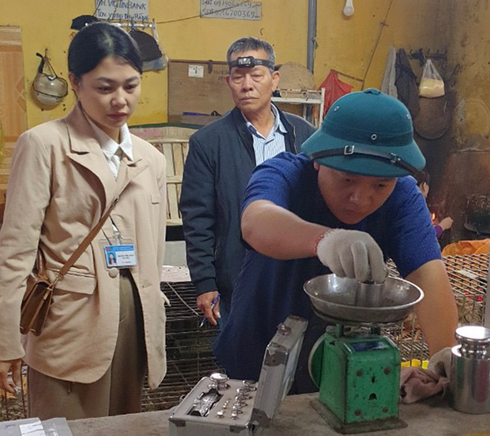 Cán bộ Trung tâm Ứng dụng, kỹ thuật, thông tin KH&CN tỉnh kiểm định cân được sử dụng trong mua bán tại chợ Nguyễn Thái Học, thành phố Yên Bái.
