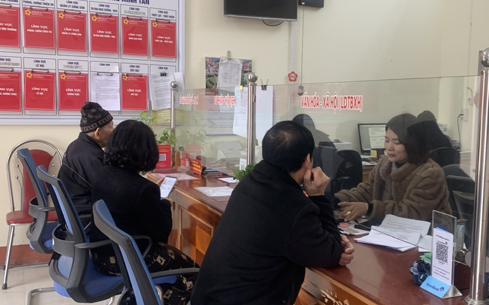 Officials at the Minh Tan Ward One-Stop Service Unit assist residents in filling out administrative procedure forms.