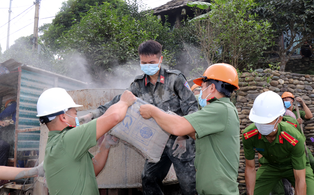 Các chiến sĩ Công an huyện Văn Chấn tham gia giúp người dân bê tông hóa đường giao thông nông thôn tại xã Suối Giàng.