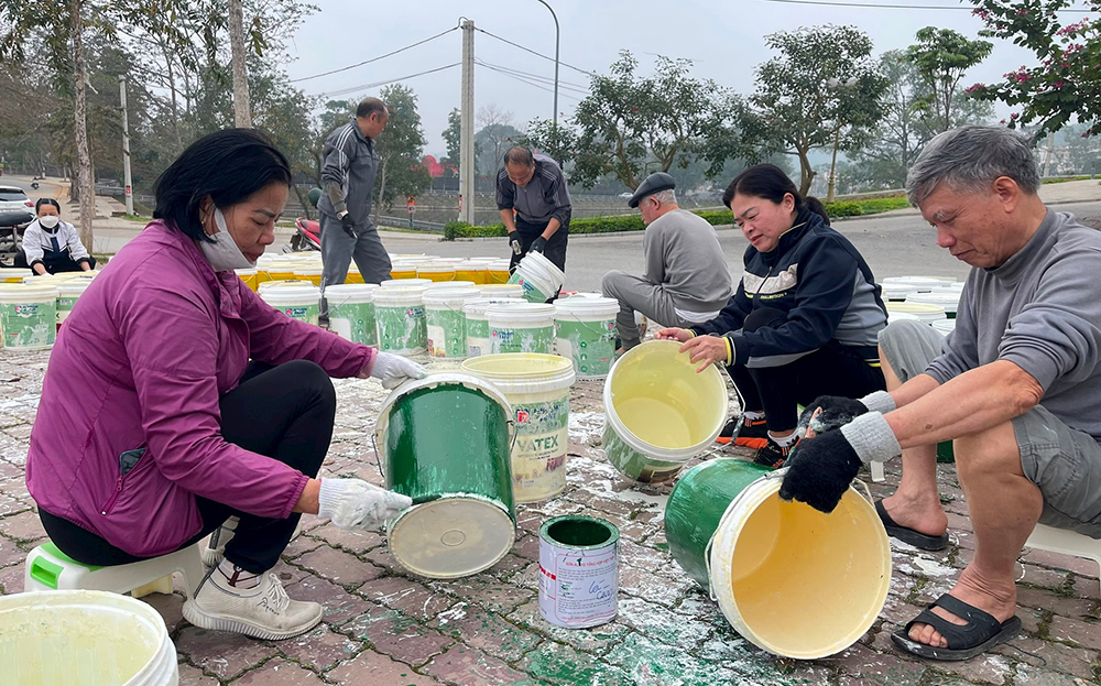 Chị em hội viên phụ nữ tổ dân phố số 2, phường Đồng Tâm tham gia sơn màu các thùng sơn để tận dụng đựng rác và phát miễn phí cho người dân.