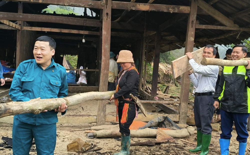 Đồng chí Trịnh Xuân Thành - Trưởng Ban Tuyên giáo và Dân vận Huyện ủy Văn Chấn cùng nhân dân tham gia giúp hộ nghèo ở xã Suối Quyền làm nhà mới.