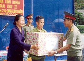 Đại tá Nguyễn Văn Khải - Phó chính ủy Bộ CHQS tỉnh tặng quà cho gia đình thương binh Đinh Kim Tuấn (Văn Chấn). (Ảnh: Thanh Năm)

