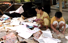 Học sinh vùng lũ thành phố Yên Bái phơi sách vở chuẩn bị cho năm học mới. (Ảnh: Thái Hoàng)

