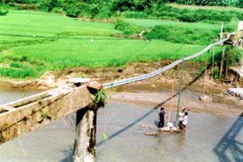 Nông dân thôn 14, xã Lâm Giang khắc phục thiệt hại bằng cách làm cầu máng đưa nước về đồng.

