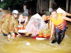 Lực lượng cứu hộ đưa một bà mẹ có con nhỏ ra khỏi khu vực ngập lũ ở phường Tam Thanh (TP Lạng Sơn).