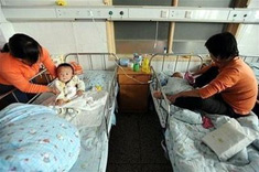 Hai phụ nữ Trung Quốc đang chăm sóc con bị bệnh do sữa melamine tại một bệnh viện ở Hợp Phì, tỉnh An Huy.