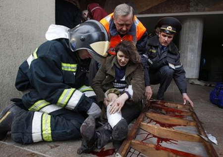 Cảnh sát, nhân viên y tế và lính cứu hỏa đưa một phụ nữ bị thương trong vụ đánh bom nhà ga tàu điện ngầm Oktyabrskaya lên xe cứu thương hôm 11/4.