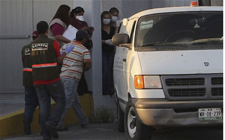 Vận chuyển thi thể các nạn nhân trong hố chôn tập thể ở Mexico.