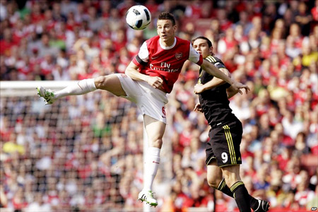 Trung vệ Koscielny (trái, Arsenal) phá bóng giải vây trước tiền đạo Carroll của Liverpool.