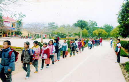 Các em học sinh trong đội cờ đỏ làm nhiệm vụ phân luồng khi tan trường.
