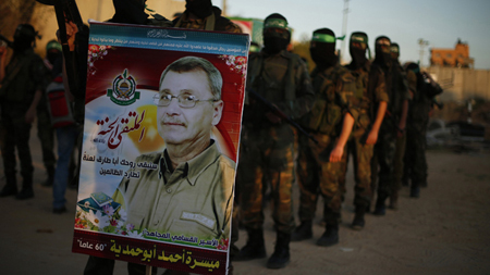 Các binh sĩ Hamas cầm ảnh tù binh Abu Hamdiyeh trong cuộc biểu tình phản đối Israel hôm 1-4 ở Gaza.