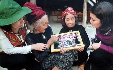 “Em gái Mường Phăng” Lù Thị Đôi (thứ 2, bên trái) luôn nâng niu kỷ vật là tấm ảnh chụp cùng Đại tướng Võ Nguyên Giáp nhân dịp kỷ niệm 50 năm chiến thắng Điện Biên Phủ năm 2014.