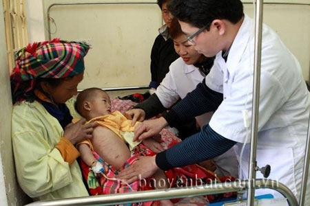 Bác sĩ Đào Thanh Quyết (người đeo kính) - Phó giám đốc Bệnh viện Đa khoa khu vực Nghĩa Lộ thăm  khám bệnh nhân sởi.