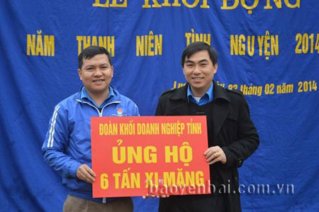 Đoàn thanh niên Khối Doanh nghiệp tỉnh (trái) ủng hộ 6 tấn xi măng xây dựng sân chơi cho trẻ em ở các thôn bản của huyện Lục Yên.